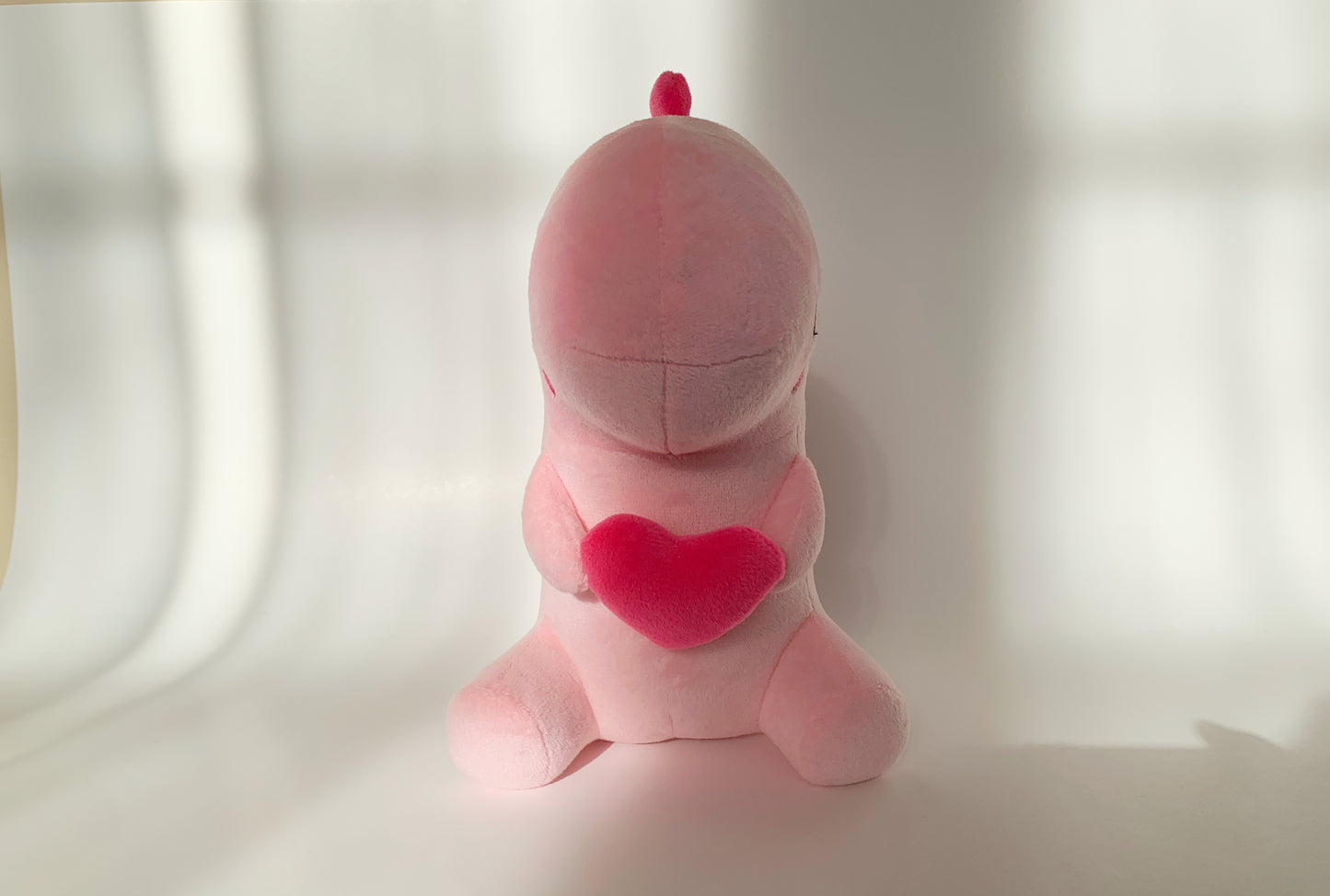 Front view of pink heart dinosaur plushie